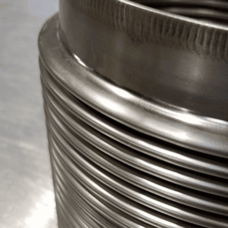 Stainless steel industrial parts stacked in a row for manufacturing applications.