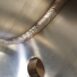 Precision weld seam on stainless steel tank for industrial processing.