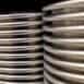 Polished stainless steel pipes stacked in industrial setting for manufacturing and construction.