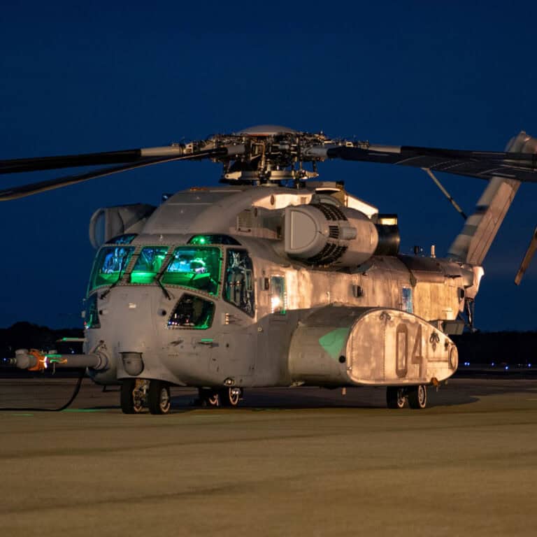 Military helicopter at night with nighttime lighting and advanced technology features.