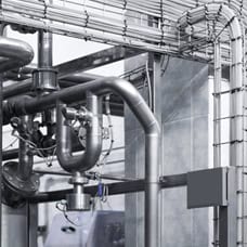 Stainless steel industrial piping system in a manufacturing plant.