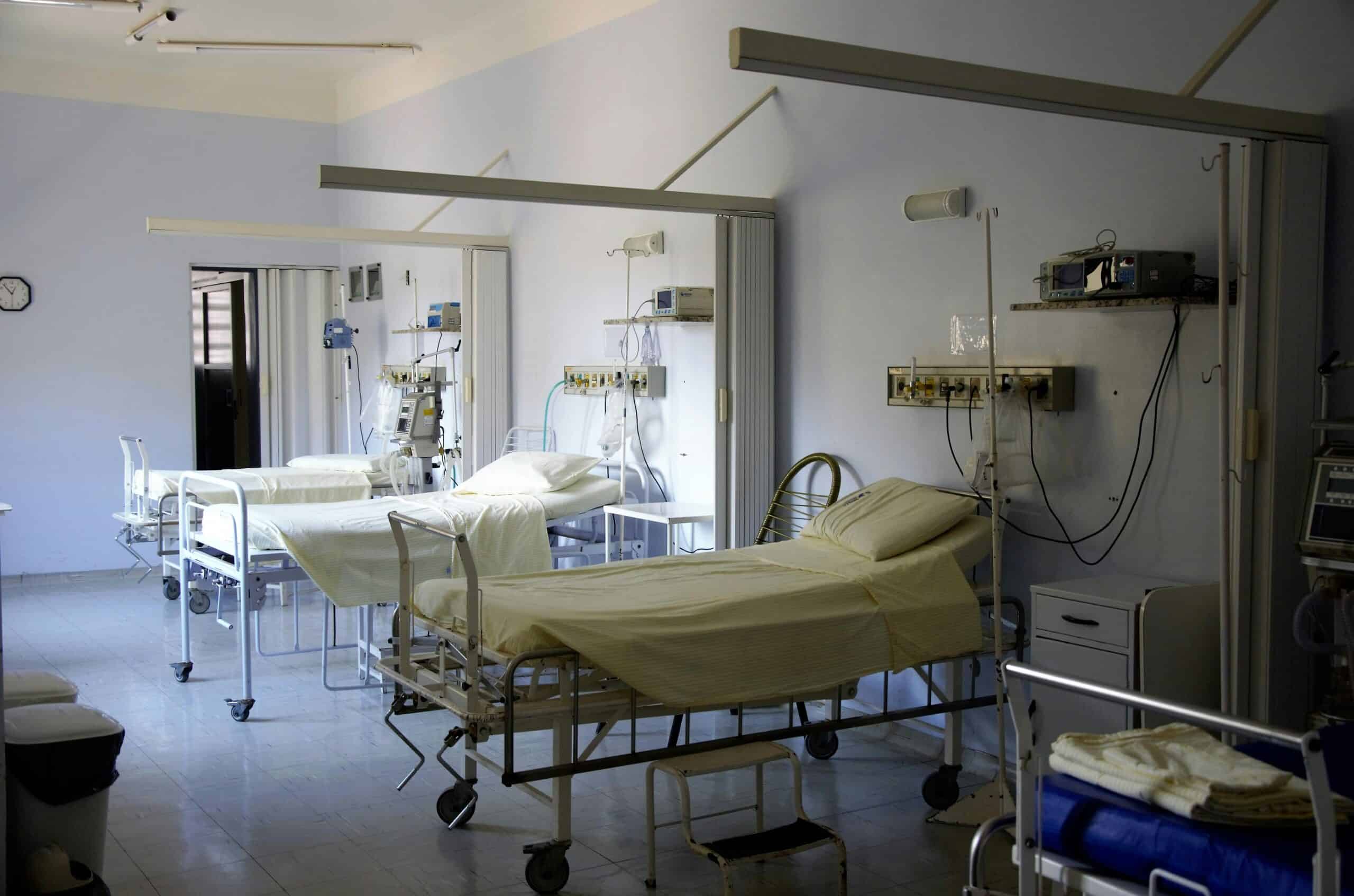 Hospital patient room with multiple beds and medical equipment, emphasizing healthcare facilities.
