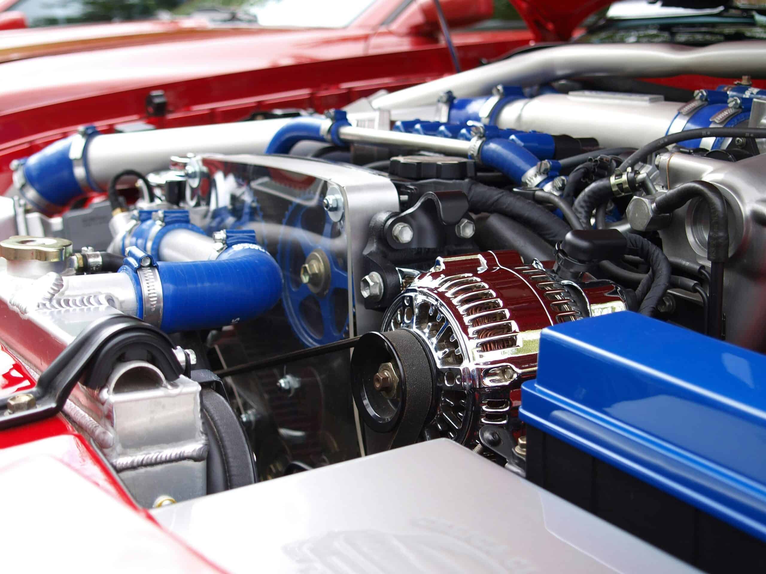 High-performance car engine with blue hoses, chrome alternator, and advanced cooling system.