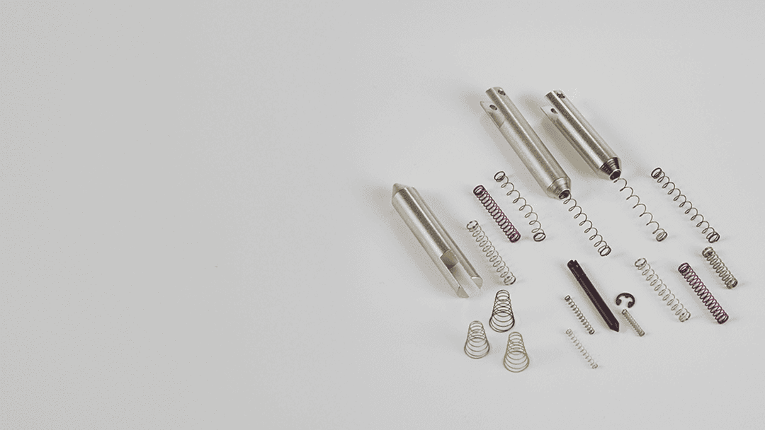 Precision industrial valve components with springs and steel parts for manufacturing.